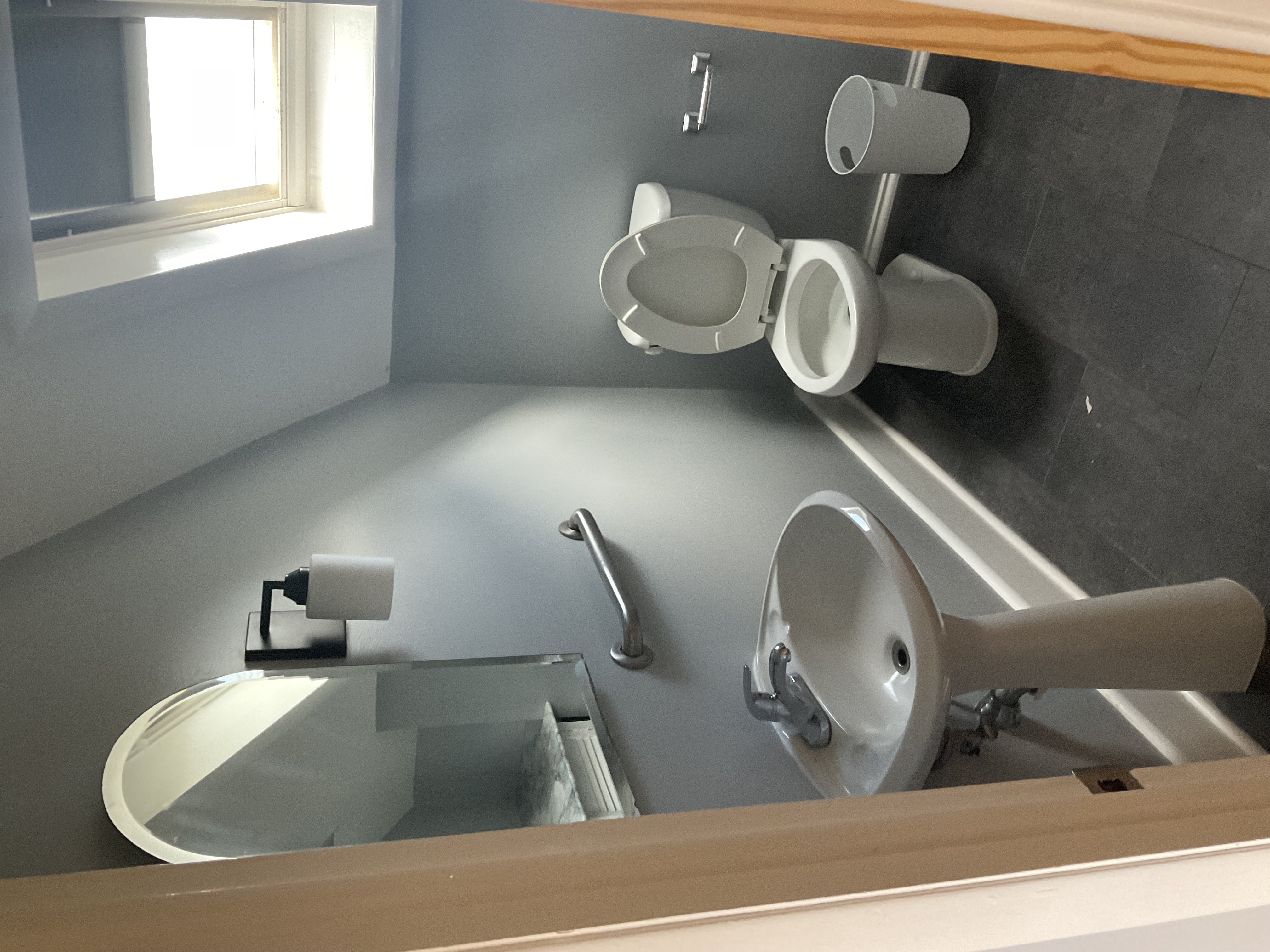 Sanitized pedestal sink, mirror, toilet, and tile floors by Ecua Housecleaning