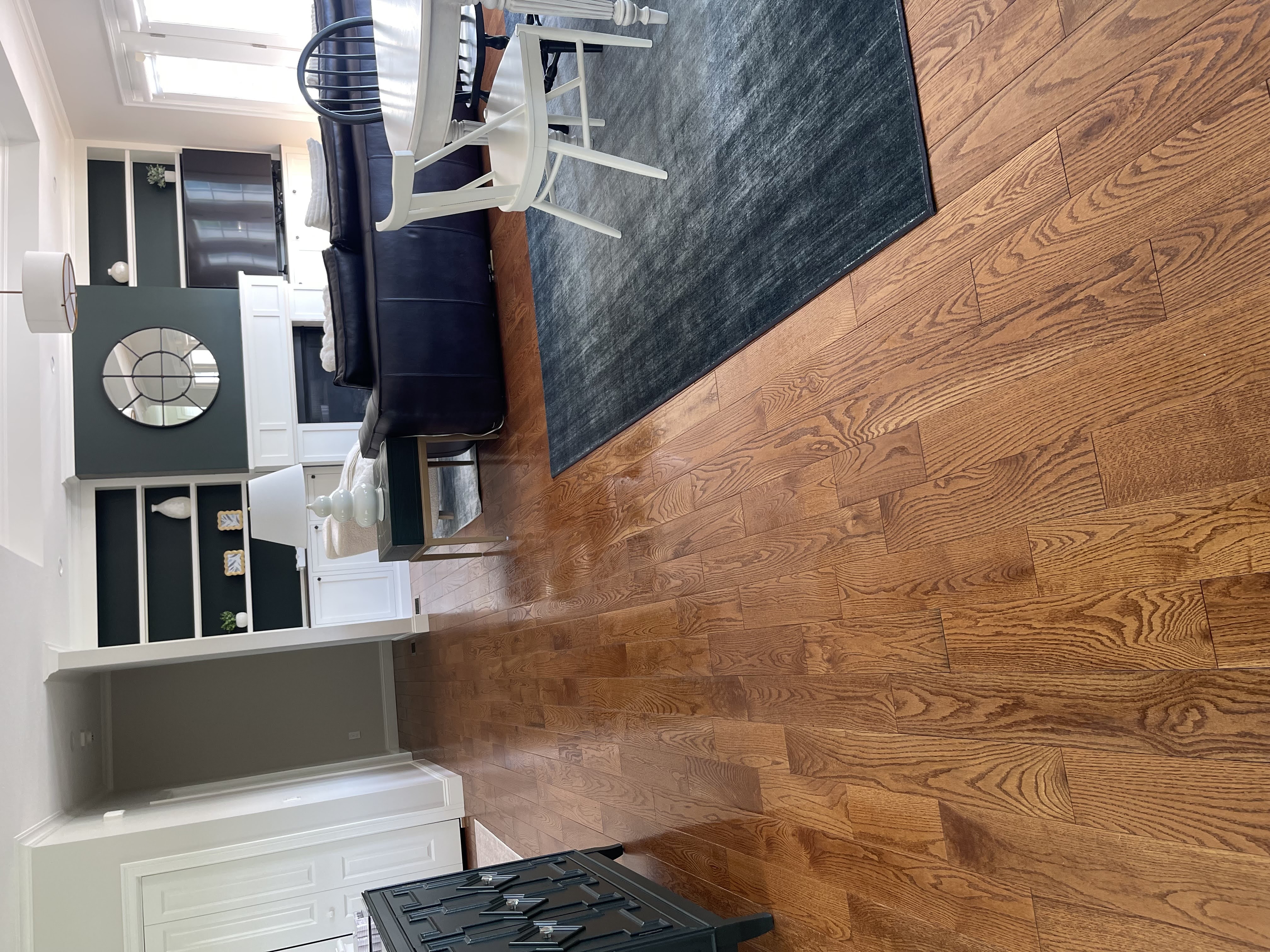 Pristine living room with polished oak hardwood floors and clean rugs by Ecua Housecleaning